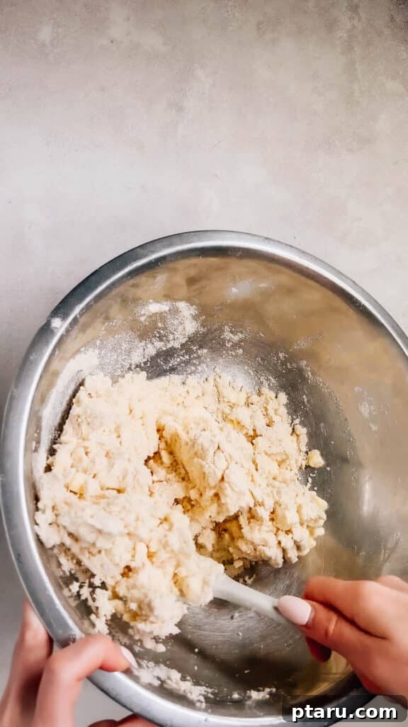 Simple Hand-Mixed Pie Crust 10 The flour and butter mixture with ice water, beginning to come together in clumps.