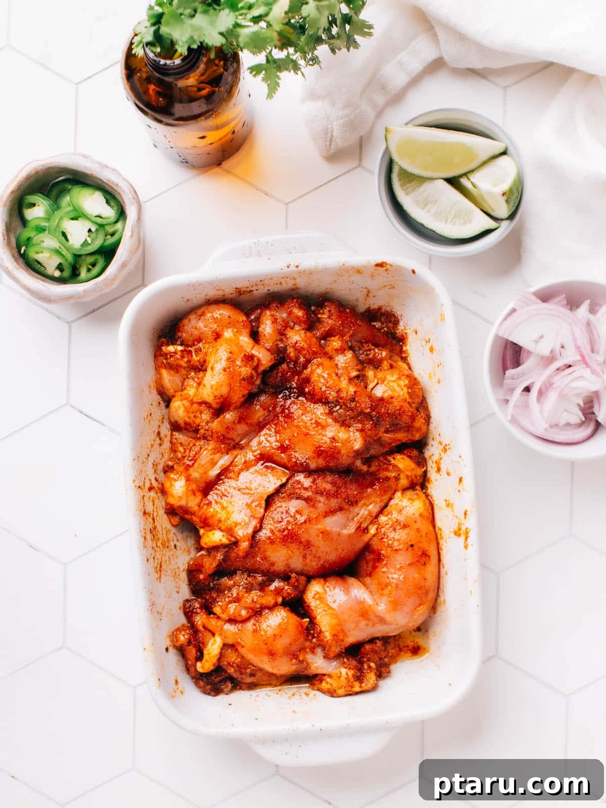 Cantina Style Chicken Tacos 9 The marinated chicken thighs are left to rest at room temperature for 30 minutes. There are individual bowls of sliced jalapenos, onions, and limes beside the chicken bowl.