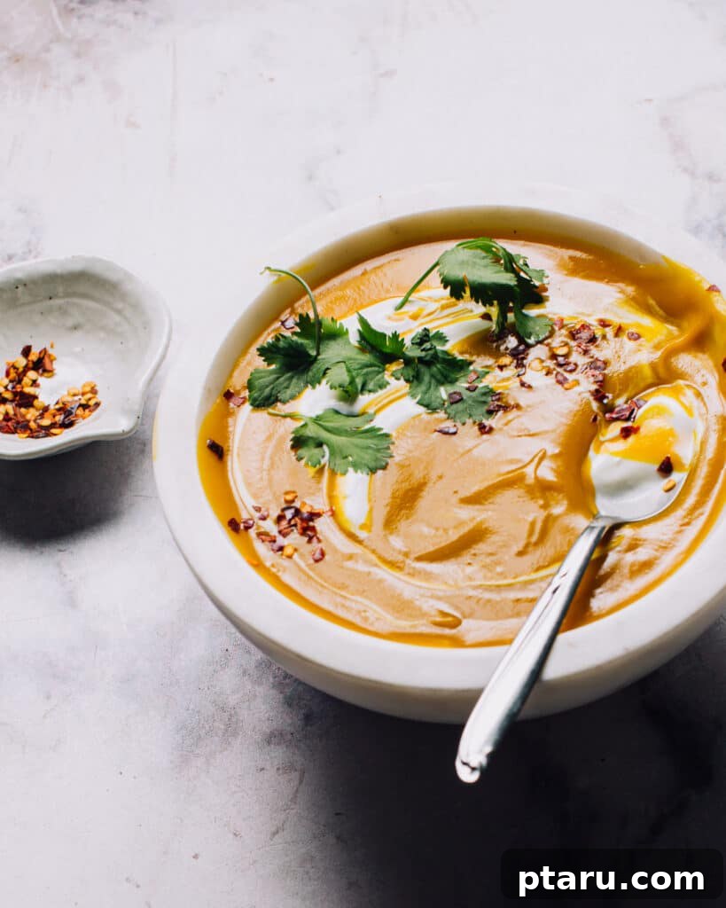 Golden Curry Chickpea and Sweet Potato Soup 2 A vibrant bowl of Sweet Potato Coconut Milk Soup garnished with fresh cilantro, ready to be enjoyed.