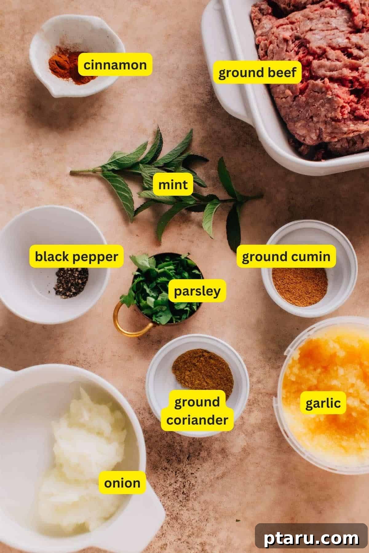 Perfectly Succulent Beef Kafta 3 Ingredients for Beef Kafta Kabob arranged on a kitchen countertop: ground beef, cinnamon, mint, black pepper, parsley, ground coriander, ground cumin, garlic, and onion.