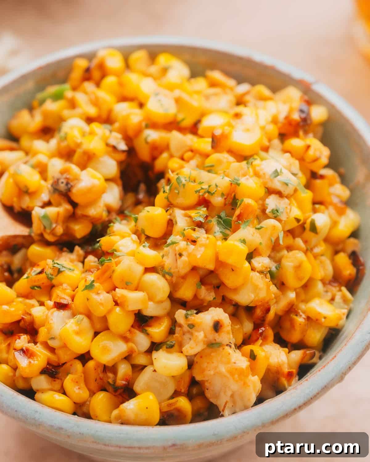 Zesty Mexican Elote Salad 6 A vibrant bowl of Mexican Corn in Cup Street Corn Salad (Esquites) garnished with fresh cilantro and lime wedges, showcasing its delicious and inviting appeal as a popular street food.
