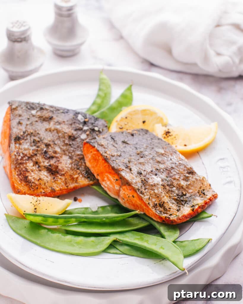 Effortless Air Fryer Pizza For Crispy Perfection 9 Air Fryer Frozen Salmon fillets on a plate, moist and flaky.