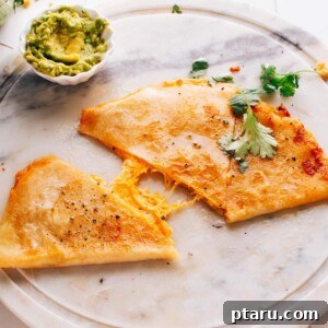 Golden Cheesy Foldover 9 A perfectly cooked cheese quesadilla cut into wedges on a plate, ready to be enjoyed.