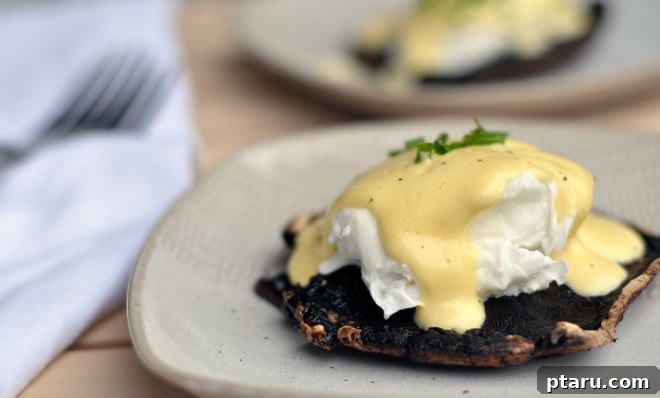 Portobello Benedict Perfection 3 Close-up of a perfectly poached egg with creamy hollandaise sauce dripping over it.