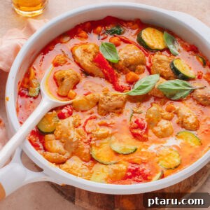 Red curry recipe in a pan with a spoon.