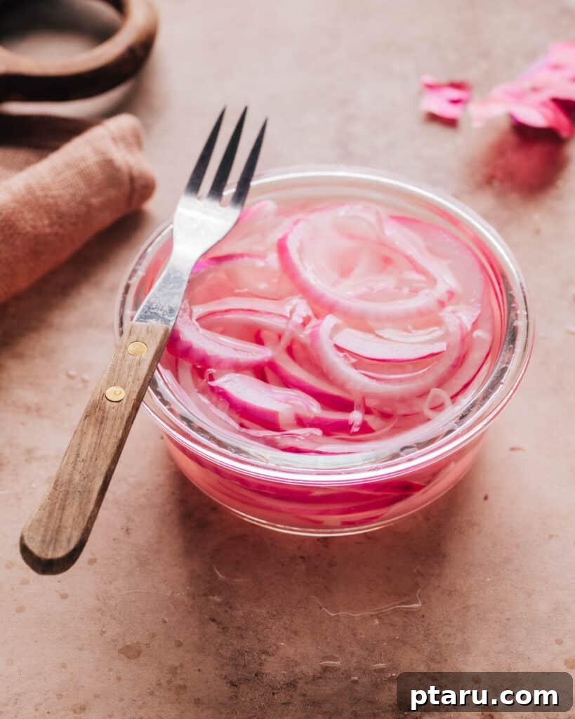 Instant Pickled Onions 2 Pickled onions in a small glass bowl with a fork on top, ready to serve.