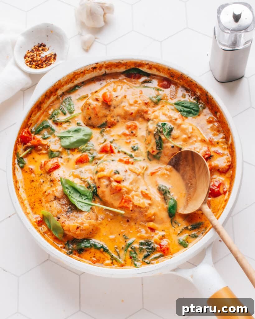 Easy 30 Minute Creamy Tuscan Chicken 2 The best Tuscan Chicken recipe in a pan with a spoon, garnished with fresh basil.