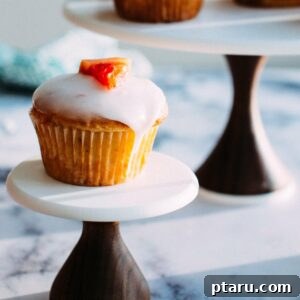 A finished Grapefruit Yogurt Muffin, perfectly glazed and garnished with a sprig of rosemary