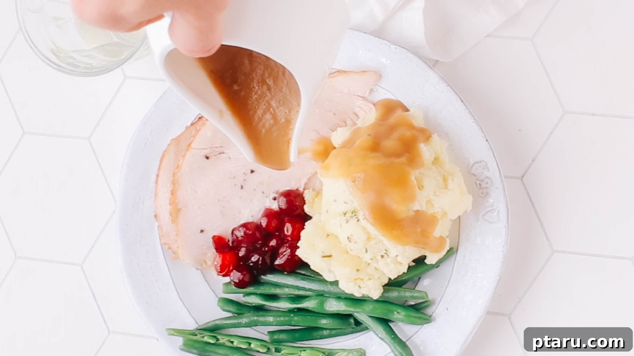 The Only Mashed Potatoes Recipe Youll Ever Need 10 Delicious gravy being poured over a classic holiday dinner plate featuring a generous serving of fluffy mashed potatoes alongside roasted turkey.