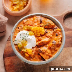 The ultimate creamy chicken chili in a bowl, garnished with corn and chilies, showcasing its rich texture and appealing presentation.