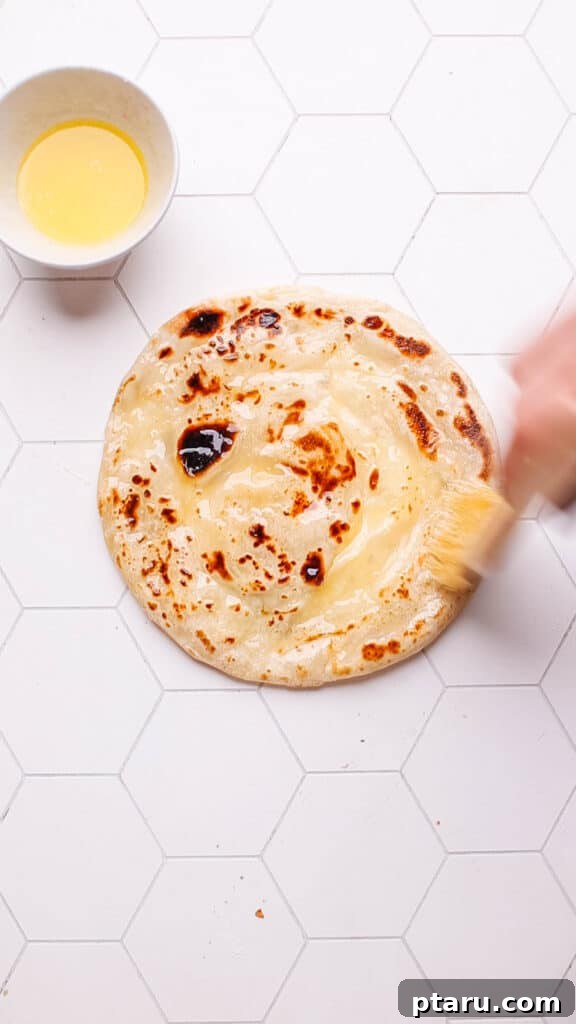 Paratha Golden Layered Indian Flatbread 17 Brushing cooked paratha with butter.