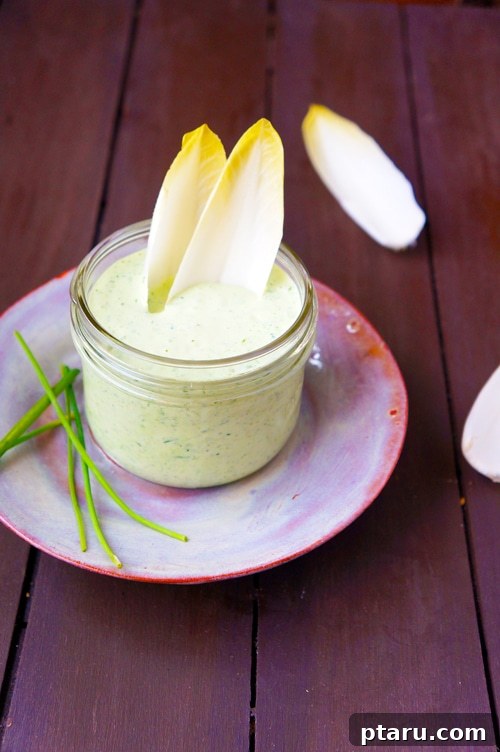 Vibrant Green Goddess Dip and Dressing 3 A close-up of a creamy, vibrant green Green Goddess dressing in a small bowl, garnished with fresh herbs, ready for serving.