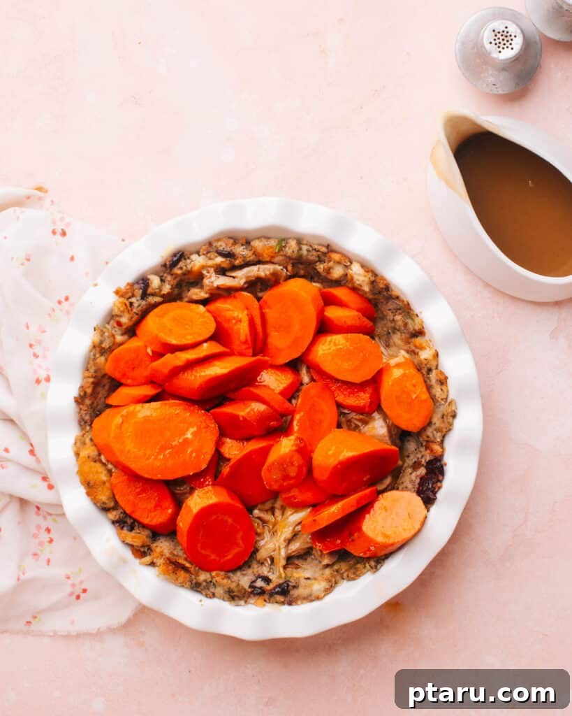 Thanksgiving Revival Casserole 7 A colorful layer of cooked mixed vegetables, including glazed carrots, spread over the turkey filling in the pie dish, adding texture and freshness.