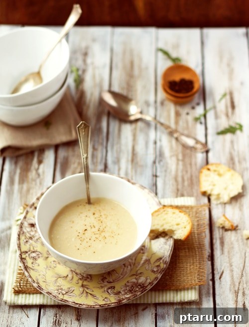 Velvety Apple Parsnip Dream 4 A person meticulously seasoning a pot of soup with sea salt using a pinch-pot.