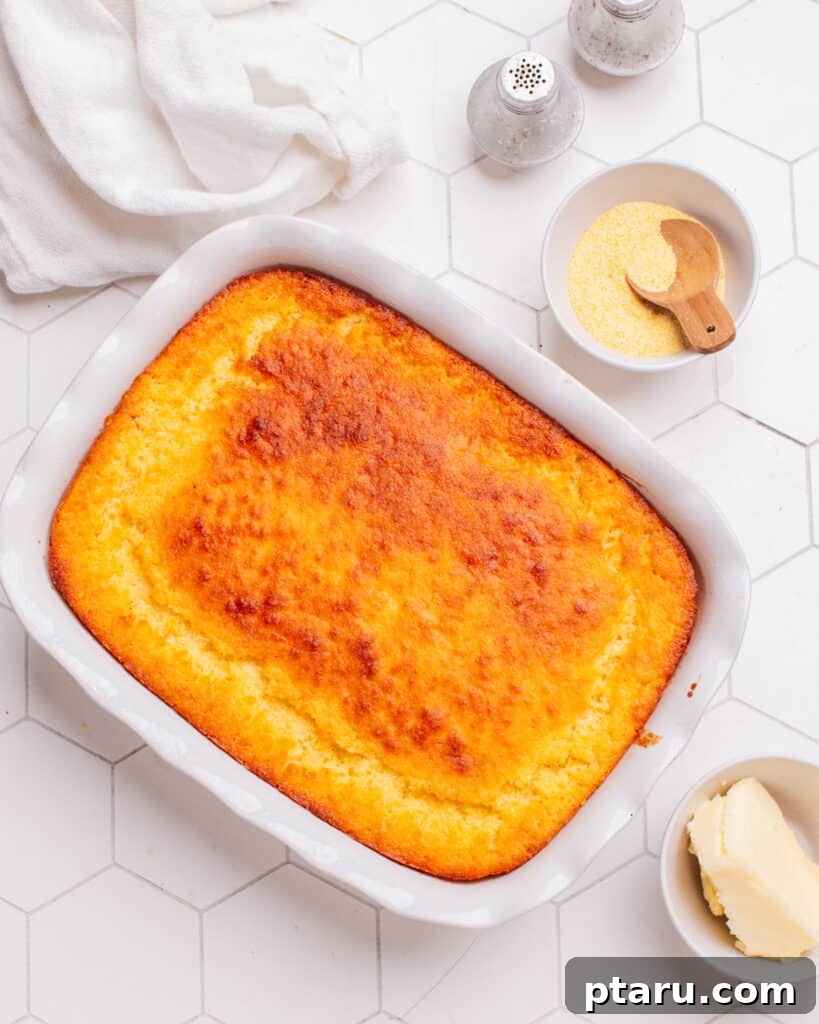 Golden Cornbread Bake 18 Cornbread casserole on the counter with cornmeal and butter beside it.