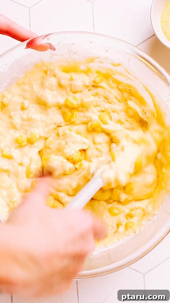 Golden Cornbread Bake 5 Stirring corn into cornbread casserole.