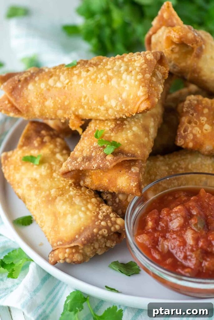 Over 35 Mouthwatering Leftover Taco Meat Recipes 21 Crunchy egg rolls stacked on a plate with a dip