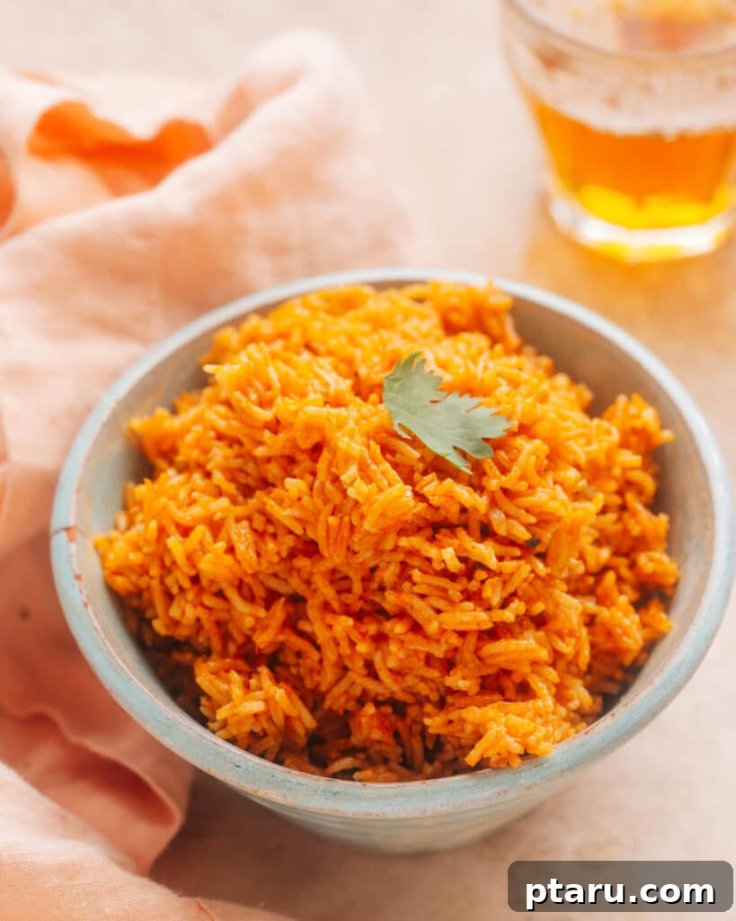 Over 35 Mouthwatering Leftover Taco Meat Recipes 25 A serving of Instant Pot Mexican rice is presented in a bowl, adorned with a sprinkle of fresh cilantro. Adjacent to the bowl, a kitchen cloth and two glasses can be seen.