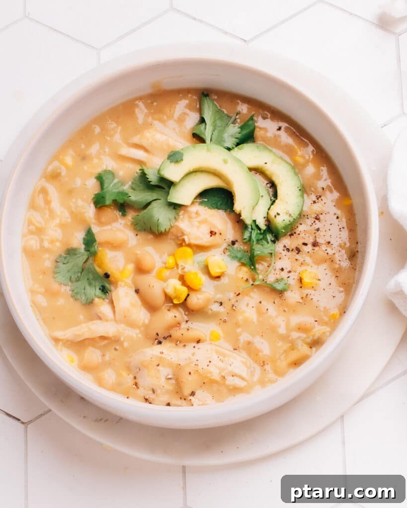 Guilt-Free White Chicken Chili 8 A beautifully presented bowl of creamy white chicken chili, garnished with avocado, cilantro, and lime, ready to be enjoyed as a hearty and healthy meal.
