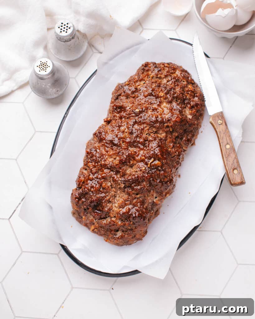 Lipton Onion Soup Meatloaf 7 Baked Meatloaf on a serving plate with a slice removed.