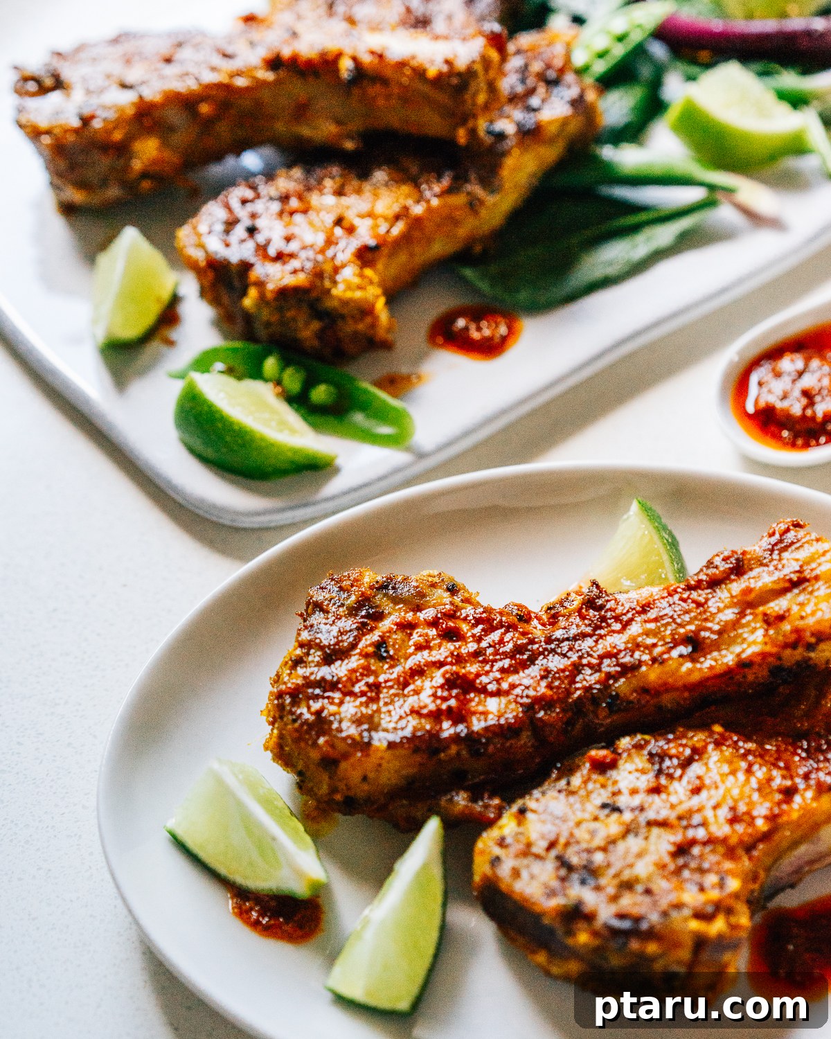 Tandoori Lamb Chops 6 Indian Lamb Chops on plates with lime wedges.
