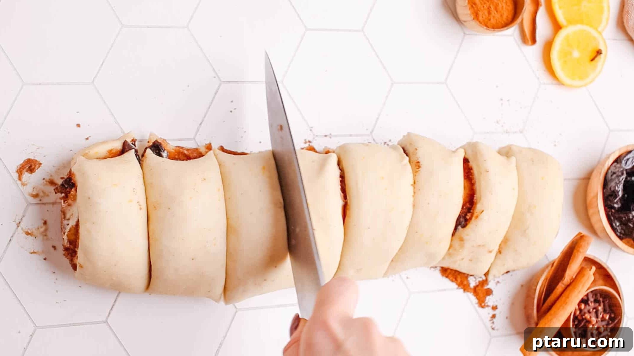 Sweet Cinnamon Raisin Swirls 8 Slicing a rolled cinnamon roll dough log into individual cinnamon roll pieces.