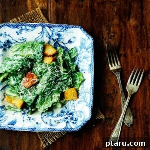 A small jar of creamy homemade Caesar dressing with a whisk beside it.