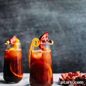 A festive glass of Christmas Sangria beautifully garnished with an orange slice, pomegranate arils, and a star anise pod.