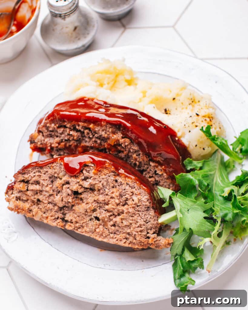 Foolproof 3 Ingredient Meatloaf Glaze 2 Meatloaf with Glaze on a plate with mashed potatoes, showcasing its glossy, appealing finish.