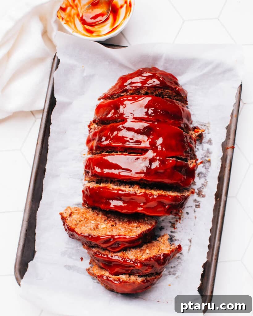 Foolproof 3 Ingredient Meatloaf Glaze 6 A glazed meatloaf resting on a baking sheet, already sliced, showcasing its perfect finish.