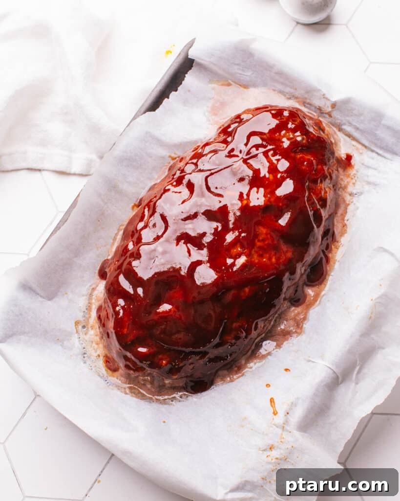 Foolproof 3 Ingredient Meatloaf Glaze 8 A perfectly glazed meatloaf resting on a baking sheet after cooking, ready to be sliced and served.