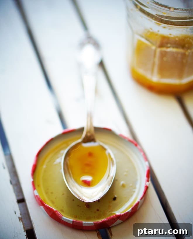 The Essential Vinaigrette 4 A bowl of fresh salad being gently tossed with dressing, showcasing the perfect amount of coating.