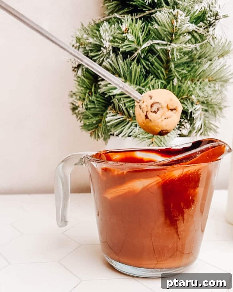 Effortless Cookie Dough Bliss 11 Each edible cookie dough ball is meticulously dipped into a pool of glistening melted chocolate, ensuring a smooth, even coating for a decadent treat.