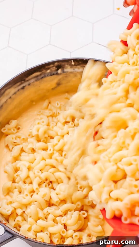 Mac and Cheese Perfection: The Ultimate Golden Sauce 6 Combining sauce and cooked macaroni pasta.