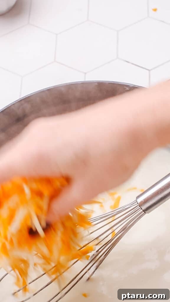 Mac and Cheese Perfection: The Ultimate Golden Sauce 8 Adding cheddar cheese to sauce for macaroni and cheese.