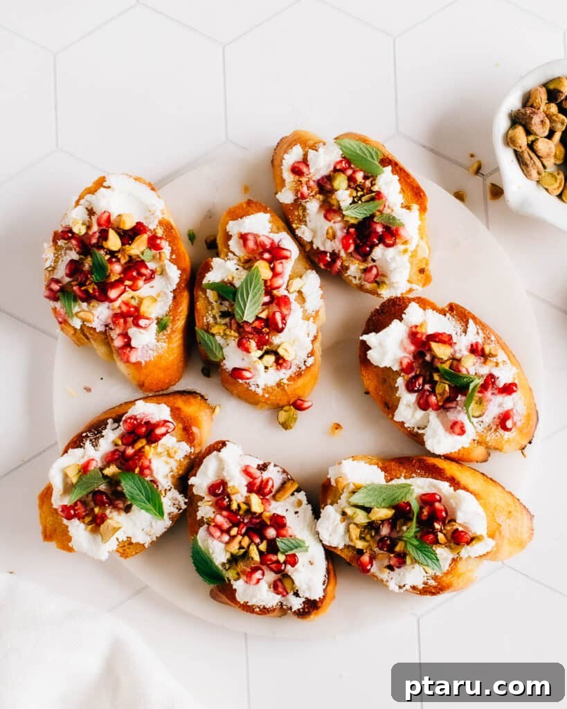 Jeweled Goat Cheese with Pomegranate and Pistachios 4 Goat Cheese Appetizer Crostini on a plate.