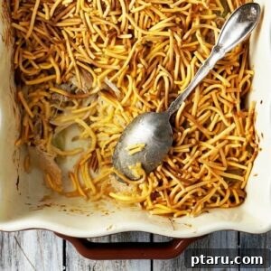 Delicious Turkey Chow Mein Casserole in a baking dish, with a serving spoon.