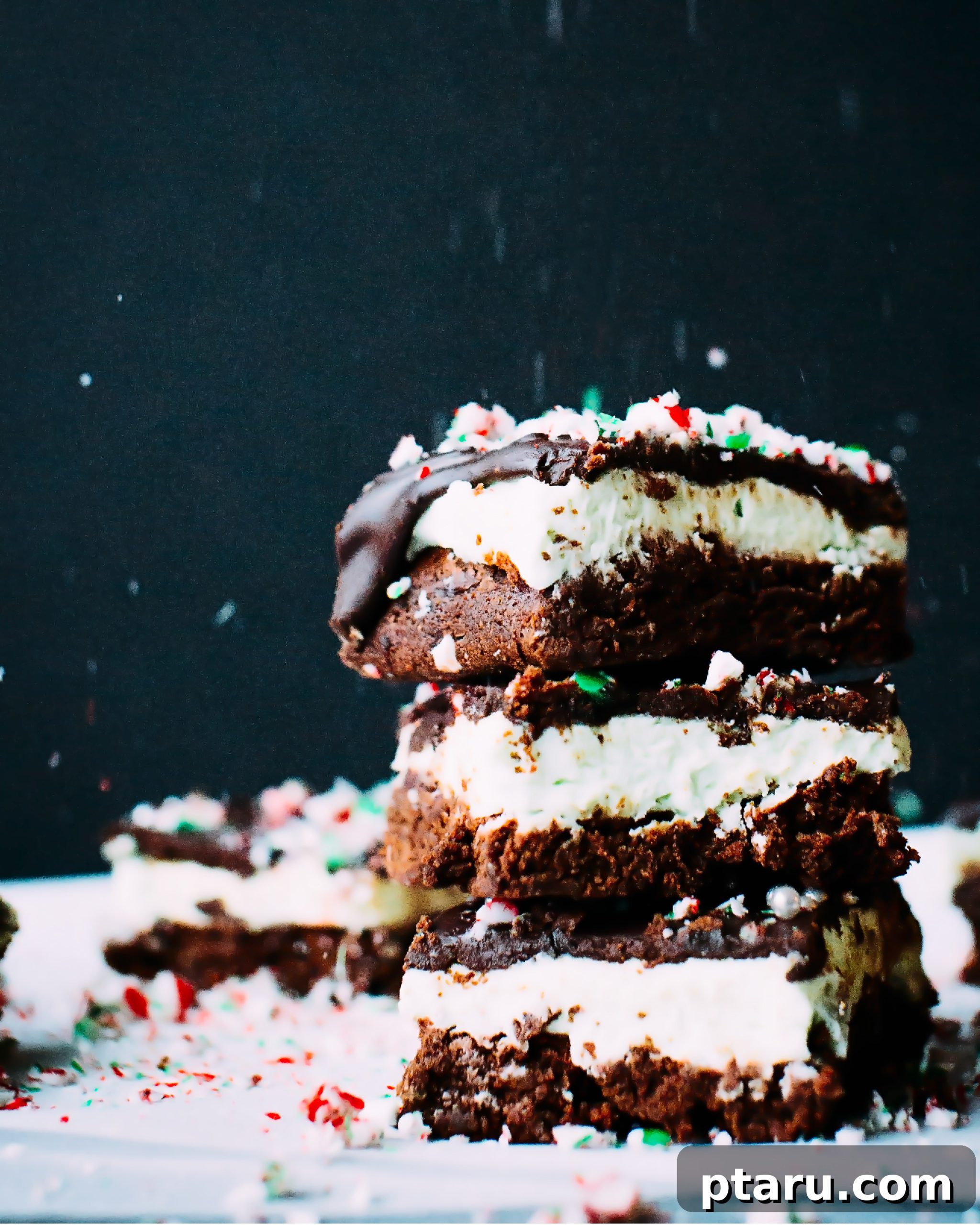 Decadent Peppermint Chocolate Brownies 2 Stacked chocolate mint brownies with peppermint icing and candy cane sprinkles, perfect for Christmas