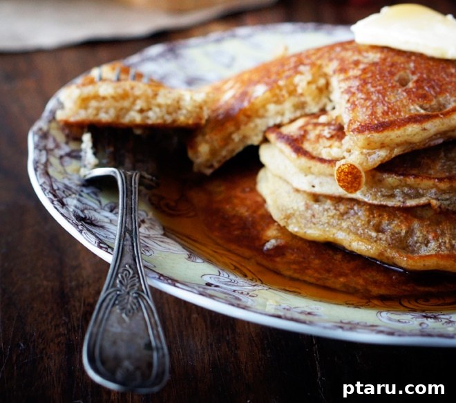 Golden Maple Almond Gluten-Free Pancakes 4 A freshly cooked gluten-free pancake stack being transferred to a baking sheet to keep warm.