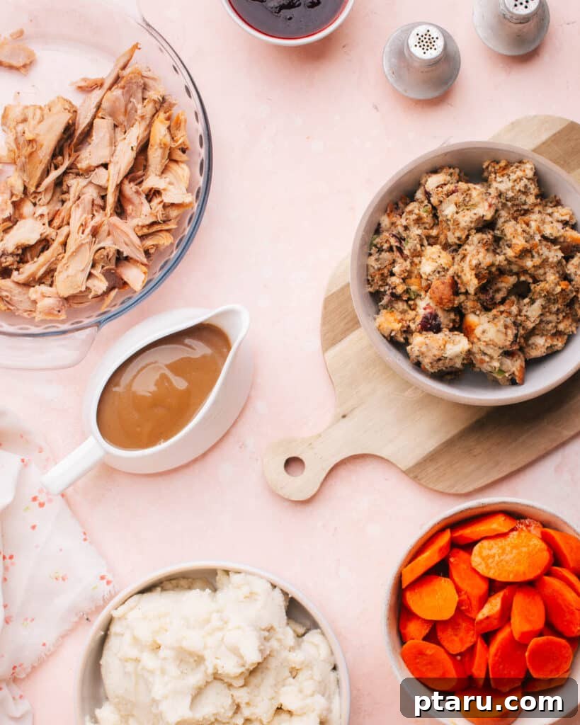 Easy Turkey Giblet Gravy No Drippings 12 A beautifully set Thanksgiving table, featuring a roasted turkey, mashed potatoes, stuffing, carrots, and a centerpiece gravy boat filled with turkey giblet gravy.