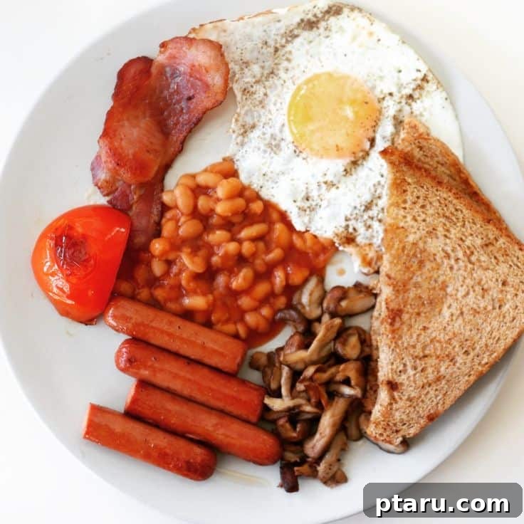 Rise and Shine: 23+ Sausage and Egg Breakfast Ideas 22 A traditional full English Breakfast spread, featuring eggs, sausages, bacon, mushrooms, baked beans, and toast.