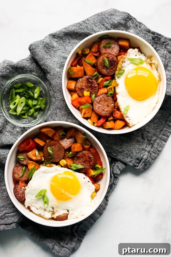Rise and Shine: 23+ Sausage and Egg Breakfast Ideas 25 A hearty bowl of Sweet Potato Breakfast Hash, featuring smoked sausage, sweet potatoes, corn, and peppers, garnished with fresh herbs.