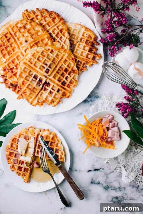Rise and Shine: 23+ Sausage and Egg Breakfast Ideas 27 Crispy Ham and Cheese Buttermilk Waffles, topped with maple syrup, ready to be served.