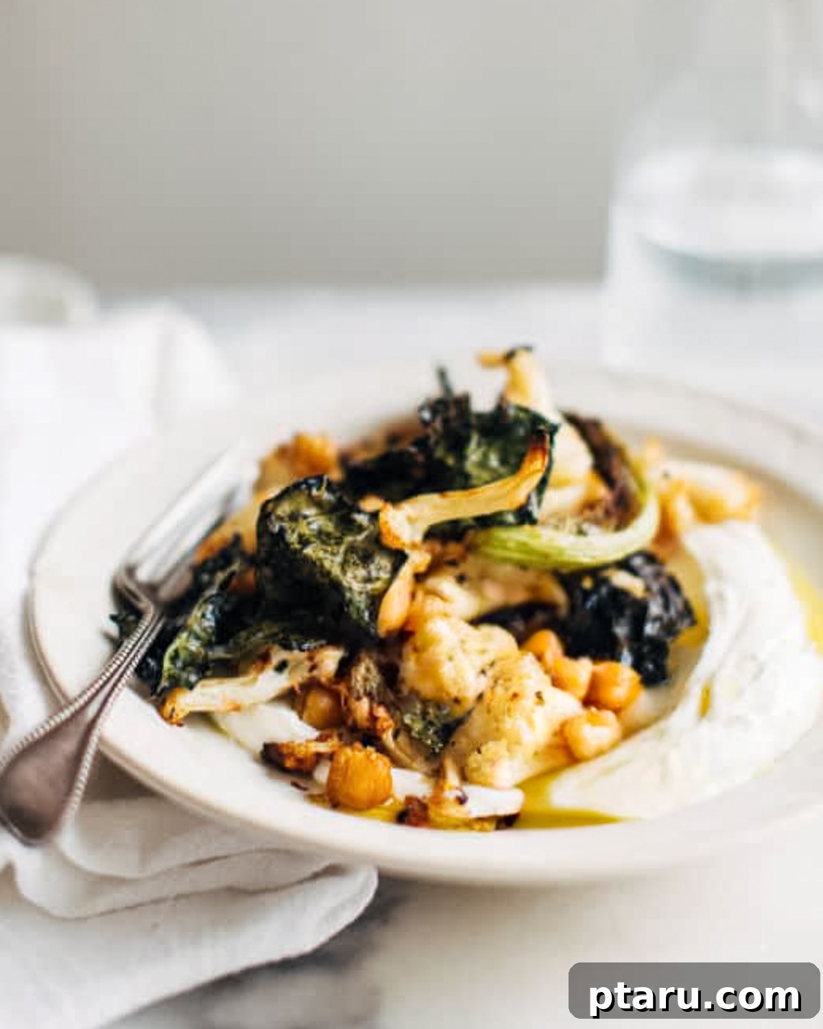 35+ Effortless Healthy Sides to Pair with Meatloaf 22 Kale Cauliflower Chickpea Salad on a plate with a fork.