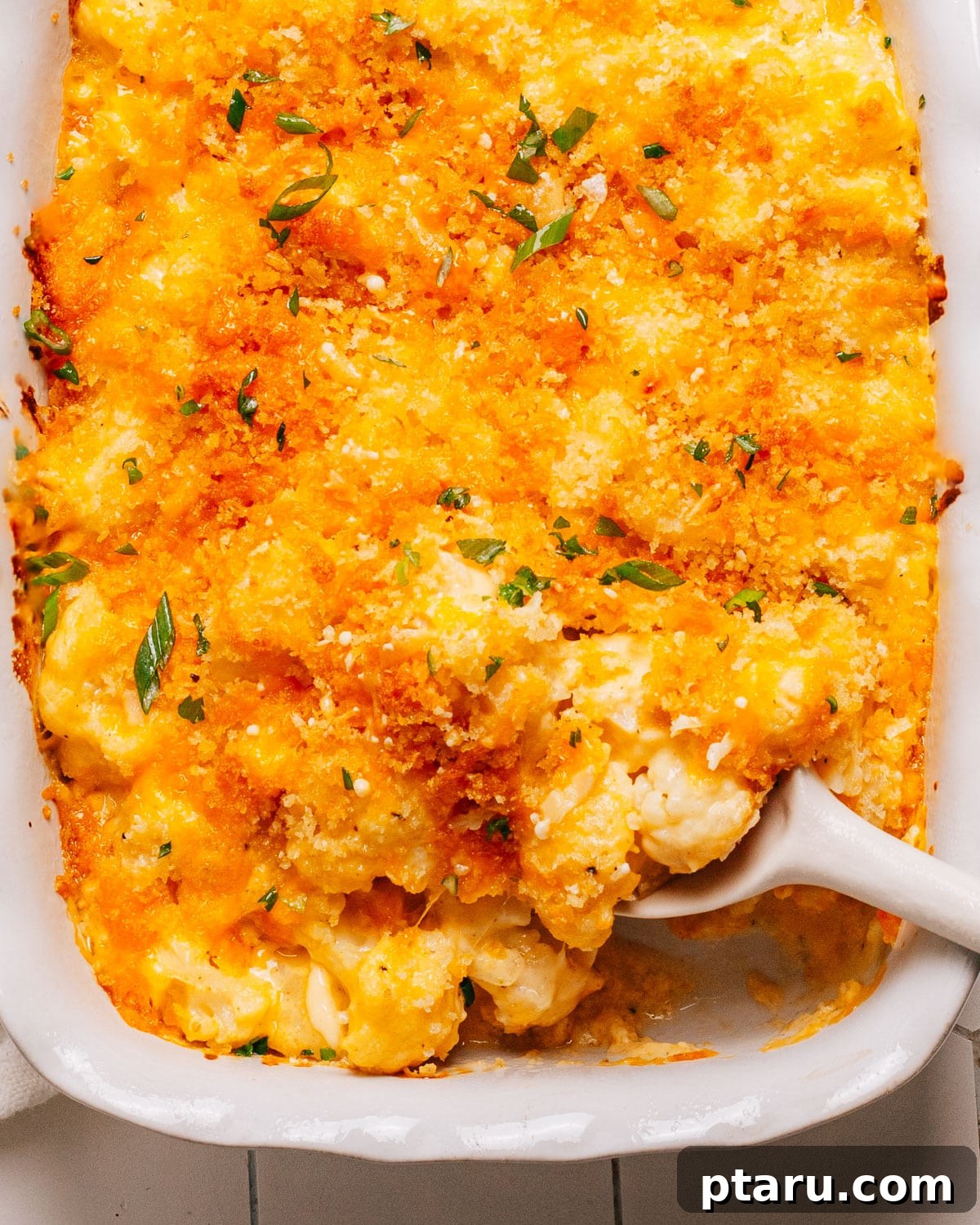 35+ Effortless Healthy Sides to Pair with Meatloaf 4 Cauliflower casserole recipe in a baking dish with a spoon.