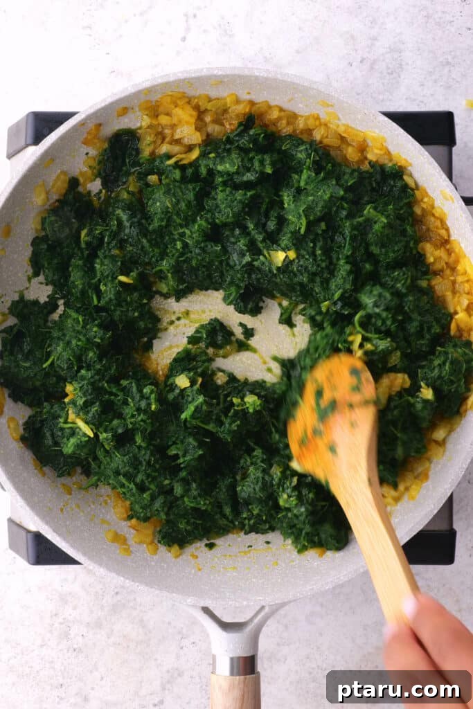 Creamy Spinach and Paneer Delight 6 Stirring spinach into saag paneer.