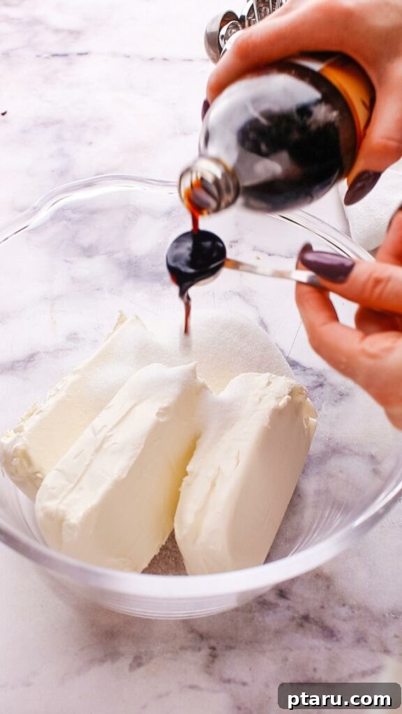 The Ultimate Philadelphia Cheesecake Guide 6 Adding granulated sugar to softened Philadelphia cream cheese in a mixing bowl