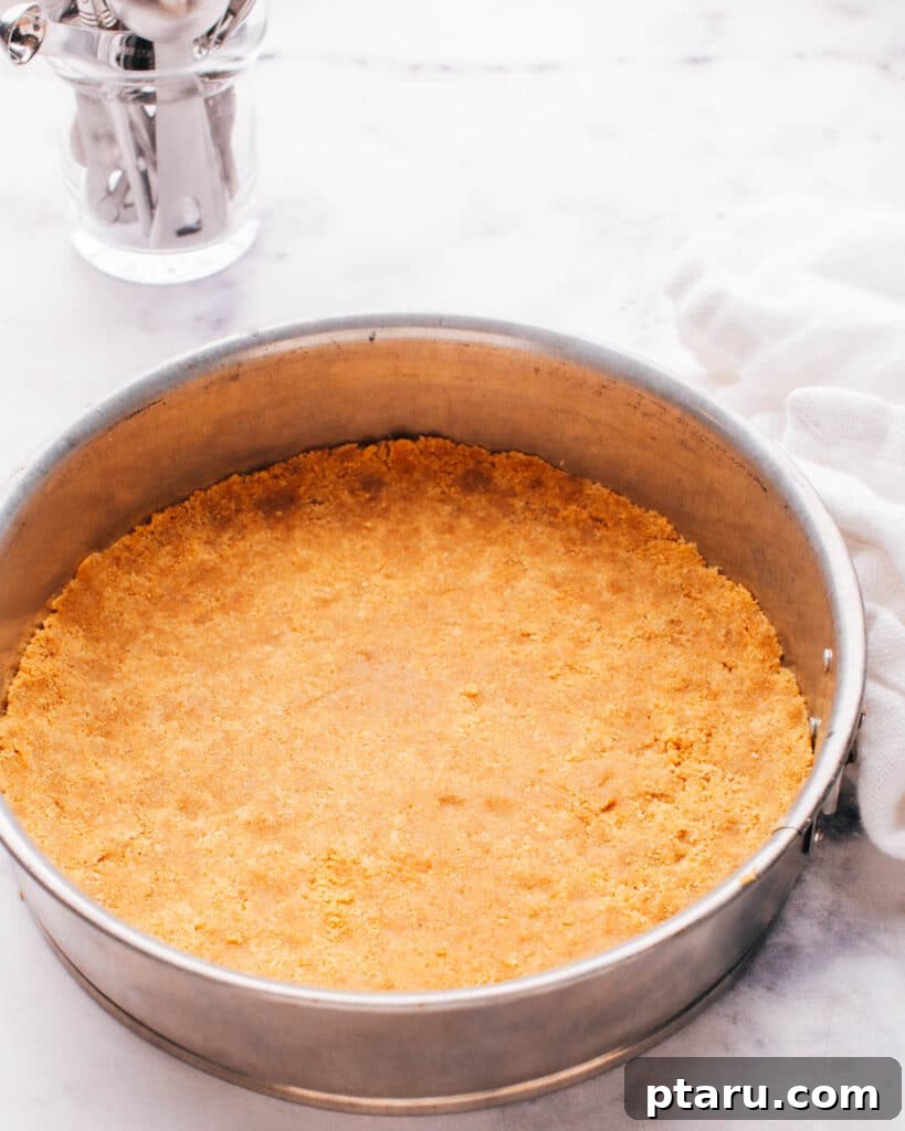 The Ultimate Philadelphia Cheesecake Guide 7 Evenly pressed graham cracker crust in a springform pan, ready for filling