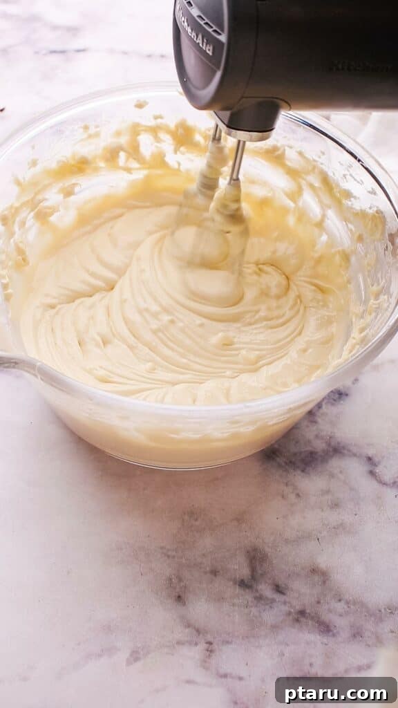 The Ultimate Philadelphia Cheesecake Guide 9 Smooth cheesecake batter being mixed in a bowl with an electric mixer