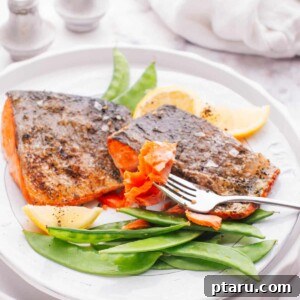 Garnished air-fried salmon fillet ready to be served, demonstrating the recipe's delicious outcome.